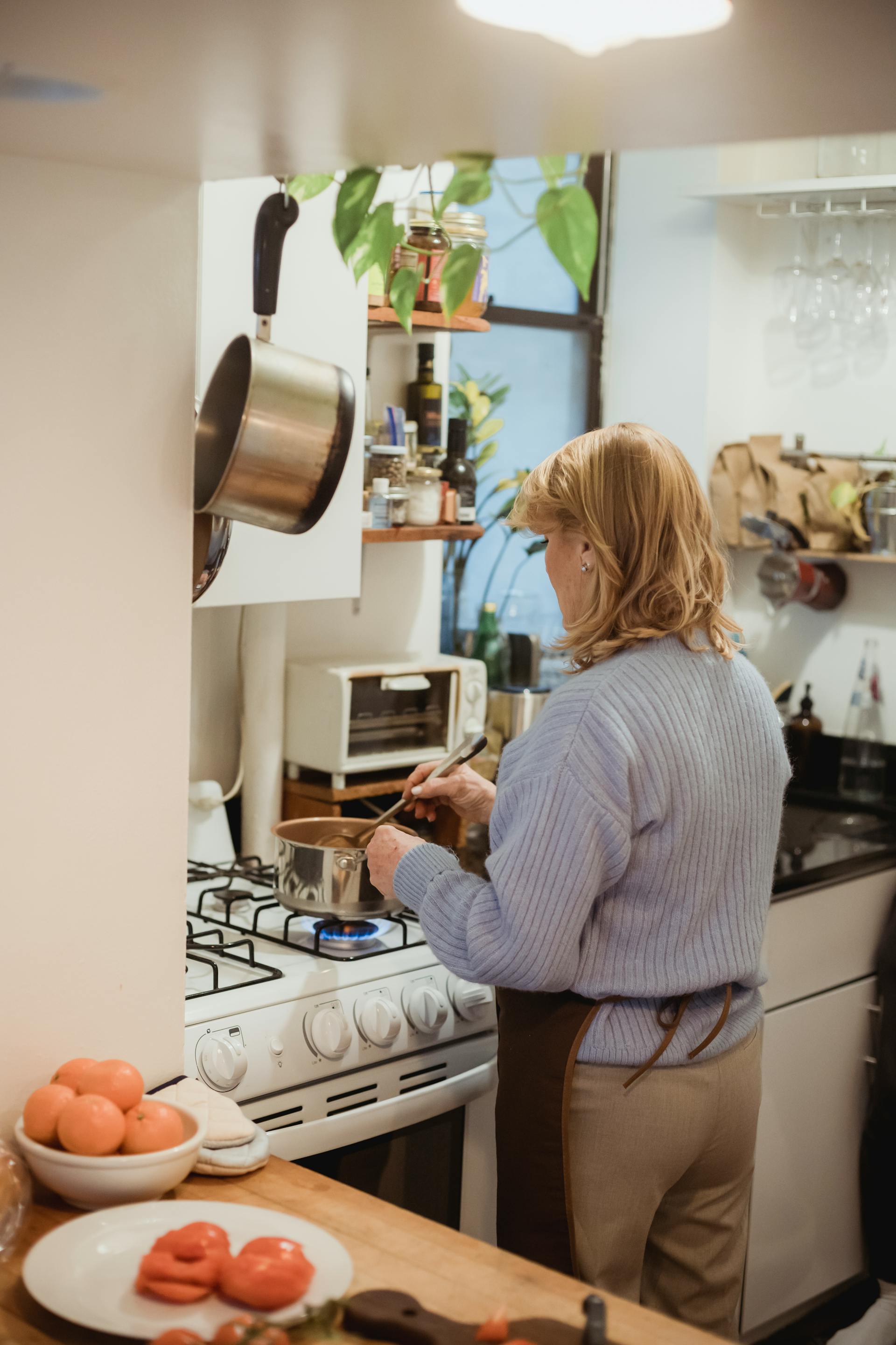 Rear view of a woman cooking | Source: Pexels