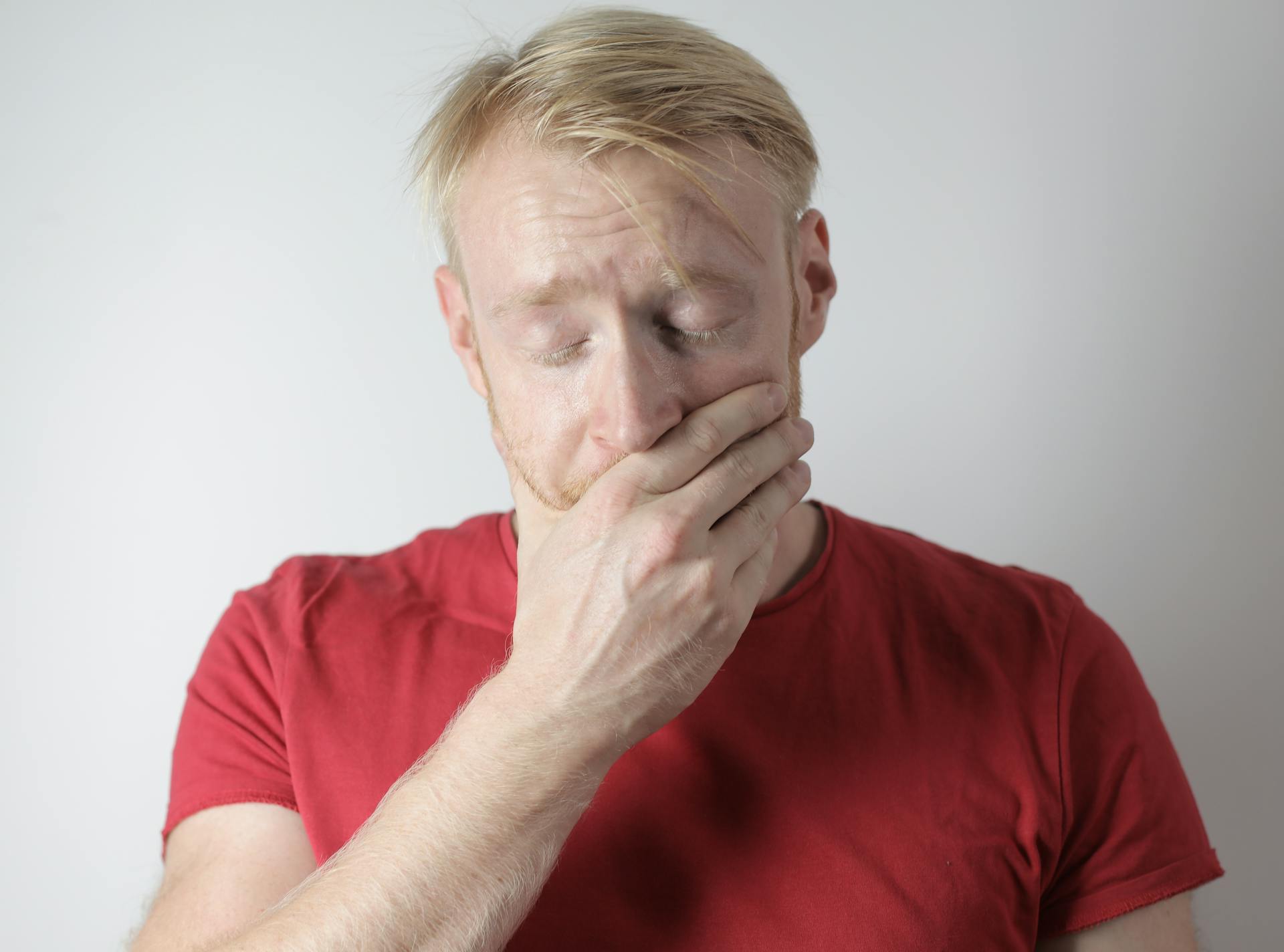 A stressed man covering his mouth | Source: Pexels